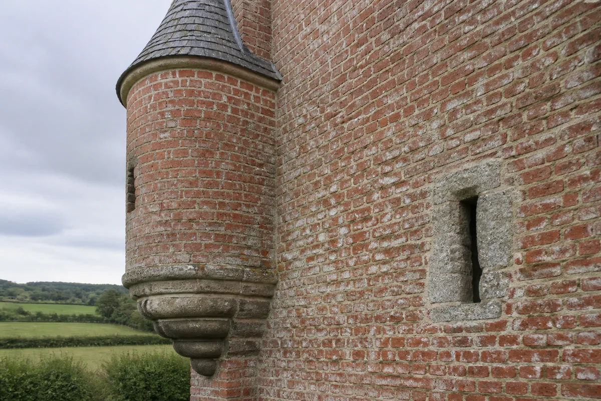Détail de maçonnerie de brique avec meurtrière et tourelle en encorbellement